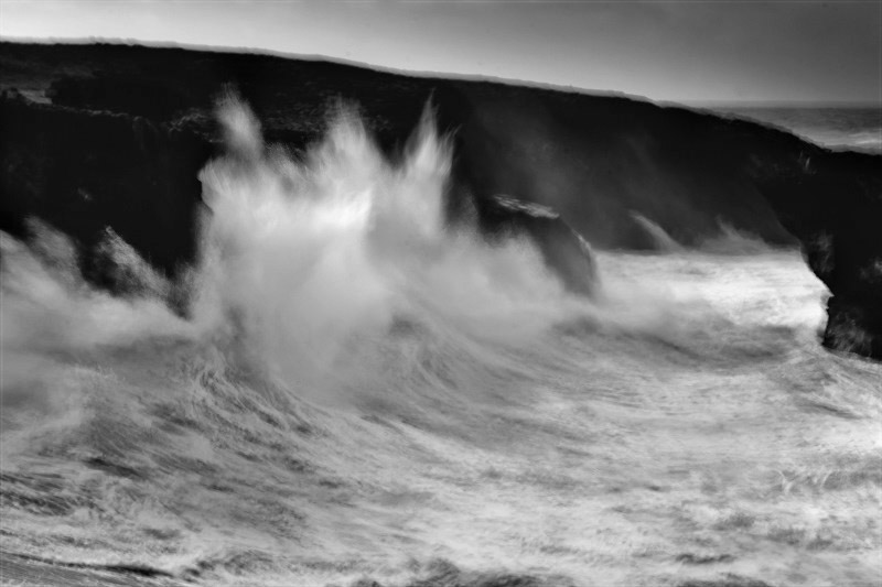 fine art black and white image of the ocean in Portugal. A wave breaking into a cliff in Sines, Alentejo, South Portugal