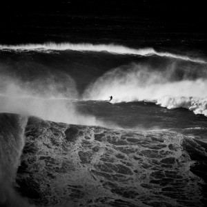 Fine art black and white image of a brazilan big wave surfer on a big wave in nazaré