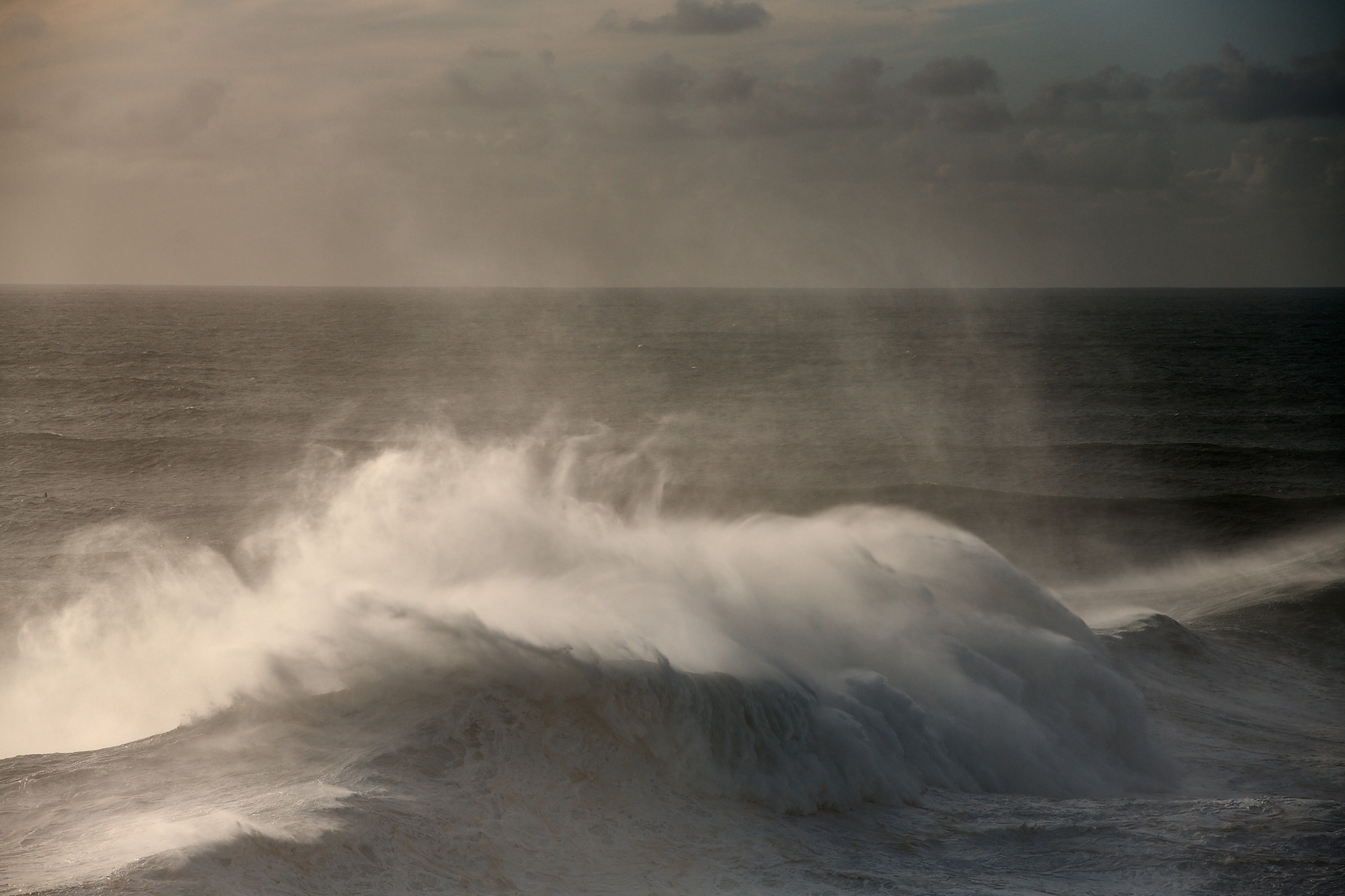 Sunset in the Atlantic sea in Nazaré during a big winter swell